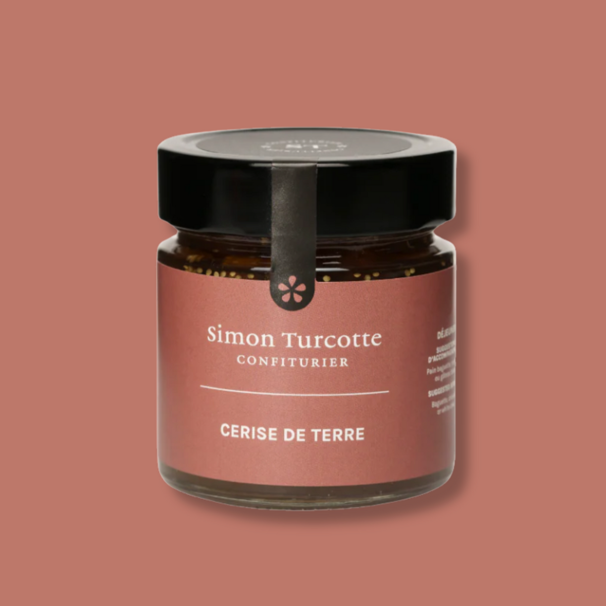 Petit pot de confiture artisanale de cerise de terre signé Simon Turcotte Confiturier. L’emballage élégant présente une étiquette aux tons terre cuite avec un couvercle noir et un sceau décoratif. Un produit raffiné qui met en valeur les saveurs douces et légèrement acidulées de la cerise de terre.